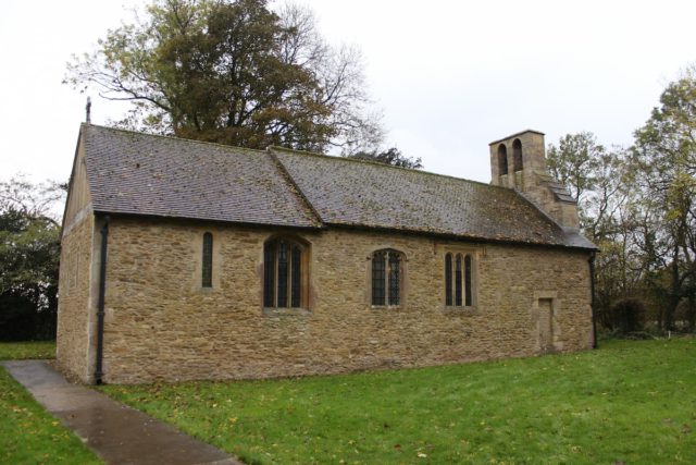 tiny stone church with tidy green lawn in the foreground